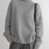 Women's cozy grey oversized cashmere turtleneck sweater with long sleeves, featuring a soft and comfortable fit.