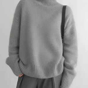 Women's cozy grey oversized cashmere turtleneck sweater with long sleeves, featuring a soft and comfortable fit.