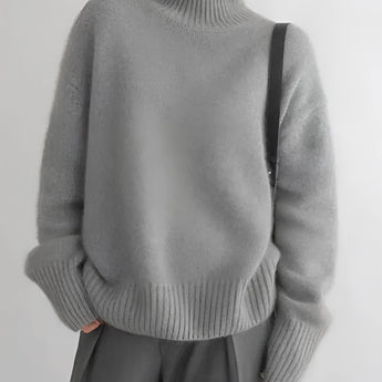 Women's cozy grey oversized cashmere turtleneck sweater with long sleeves, featuring a soft and comfortable fit.