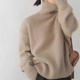 Women's oversized cashmere turtleneck sweater in a khaki color, featuring a loose fit with long sleeves and a high neck design.