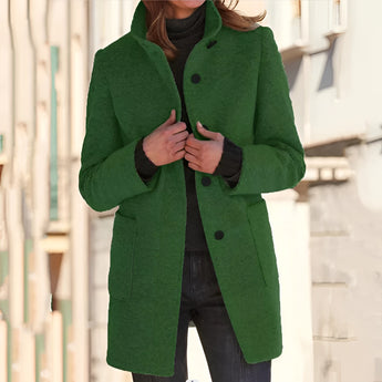 Women's cozy grey wool mid-length winter coat featuring a notch lapel and three-button design, shown in a standing pose highlighting the shoulder and sleeve details.