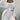 Women's cozy knit loungewear set in white, featuring a hooded cardigan and drawstring crop top in size 3XL. The image highlights the garment's long sleeves, comfortable fit, and soft texture.