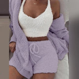 
A woman wearing a purple and white cozy lounge set consisting of a soft V-neck top with sleeves and fluffy shorts. The outfit is in a 3XL size and features a comfortable fit around the arms, shoulders, waist, and thighs.