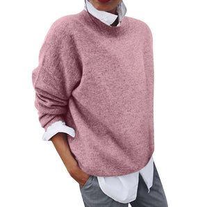 Women's pink knit sweater with a loose fit and high neck, featuring long sleeves and a cozy texture, ideal for fall fashion.