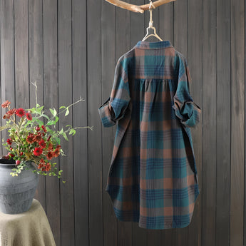 Women's cozy linen dress in a plaid pattern, vintage autumn style, midi length with sleeves, shown in a grey tartan print, surrounded by flowers and plants.