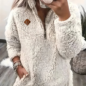 Women's cozy sherpa fleece half-zip pullover in a cream color, featuring a high collar and long sleeves with a relaxed fit suitable for loungewear. The garment is showcased in a white, size 2XL.