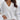 Women's white XXL deep V-neck sweater featuring button cuffs, long sleeves, and a relaxed fit, suitable for office wear or casual outings.
