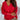 Women's deep V-neck sweater with button cuffs, showcased on a model wearing jeans. The sweater is knitted and designed for both office and casual settings. The model's hand gestures highlight the sweater's sleeves, emphasizing its cozy texture.