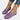 A pair of women's purple denim flats featuring a chain ankle bracelet, shown on a person wearing blue denim pants.