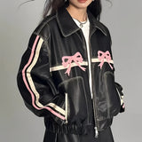 Women's designer leather jacket featuring a bow motif and metallic stripes, predominantly white with black accents, showcasing a stylish design with a structured collar, defined waist, and long sleeves, emphasizing modern fashion elements.