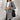 Women's double-breasted long gray winter coat with chic urban style, featuring a fashionable overcoat design with structured shoulders, long sleeves, and a tailored waist.