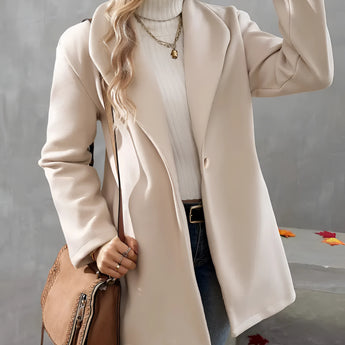 Elegant cream wool oversized winter coat worn by a woman, showcasing fall fashion style. The coat complements denim jeans and shoes, accessorized with sunglasses, highlighting a chic and modern look.