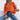 Women's elegant white V-neck knit sweater featuring lantern sleeves, shown in the orange XL variant, styled with jeans and sunglasses.
