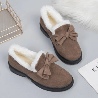 Women's brown faux fur-lined suede loafers featuring a bow tie design, showcasing their natural material and pattern.