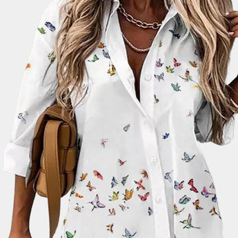 Elegant women's floral blouse featuring a V-neck design with 3/4 sleeves, predominantly in white with purple floral patterns. This blouse is styled in a beige color and is available in a 2XL size, showcasing a fashionable and sophisticated look.