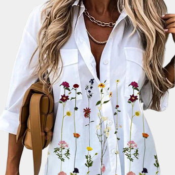 Elegant women's floral blouse featuring a 3/4 sleeve design with a v-neck, showcasing a white base adorned with purple flower patterns, in size 2XL.