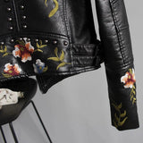 Women's floral embroidered white leather jacket with long sleeves and a stylish collar, showcasing intricate floral embroidery and luxurious designer details.