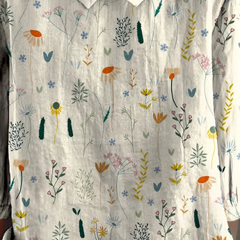 Women's white floral print short sleeve linen blouse with a V-neck, featuring light green and yellow patterns.