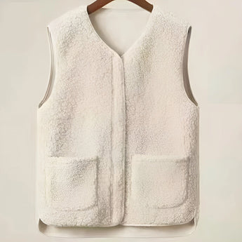 Women's fuzzy shearling zip-up vest in grey and beige tones, featuring a high collar and cozy winter fashion design, perfect for layering over a long-sleeve top.