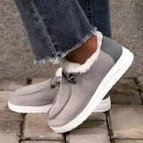 Women's gray fleece-lined winter loafers on feet, shown outdoors on grass, showcasing their stylish slip-on design and warm lining, ideal for cold weather.