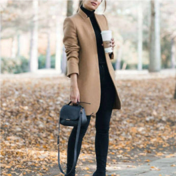 
A woman wearing a khaki-colored wool coat with a slim fit and turtleneck design, standing outdoors. The coat has long sleeves and a chic, cozy style.