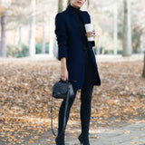 
A women's dark blue slim fit wool coat featuring a turtleneck design. The coat is styled with long sleeves and extends to knee length, showcasing a chic and cozy fashion statement suitable for colder weather.