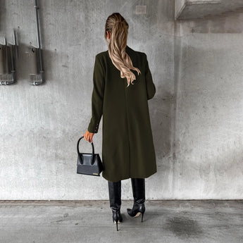 Women's gray wool knee-length coat featuring a stylish collar and waist detail, perfect for urban fashion. The coat is paired with shoes, highlighting the full look.