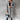 Women's gray wool knee-length coat in an urban fashion style, featuring a structured design with long sleeves and a classic collar, suitable for a sophisticated and modern look. The coat is worn by a standing model, showcasing its fit and elegance in a 3XL size.
