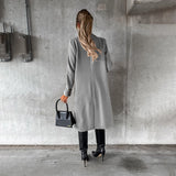 Women's knee-length gray wool coat with collar, button details, and long sleeves, styled for urban fashion.