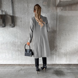 Women's knee-length gray wool coat with collar, button details, and long sleeves, styled for urban fashion.