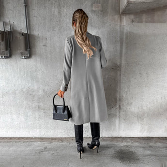 Women's knee-length gray wool coat with collar, button details, and long sleeves, styled for urban fashion.