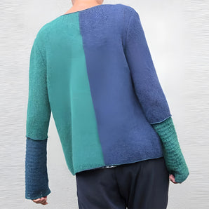 Women's green and blue two-tone color block knit sweater featuring long sleeves and a round neckline.