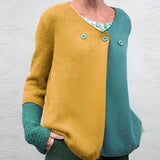 Women's green and blue two-tone color block knit sweater featuring long sleeves and a round collar.