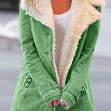 Women's green winter coat with fleece lining and white sherpa trim, featuring long sleeves and a high neck design. The coat is displayed on a mannequin or model, highlighting the outerwear's fashion-forward style and cozy textile suitable for colder weather.