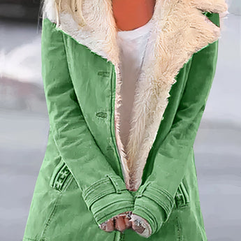 Women's green winter coat with fleece lining and white sherpa trim, featuring long sleeves and a high neck design. The coat is displayed on a mannequin or model, highlighting the outerwear's fashion-forward style and cozy textile suitable for colder weather.