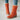Women's green suede shearling block heel ankle boots with a hint of orange on the trim, displayed on a model's foot. The boots feature a stylish and warm design suitable for colder weather.