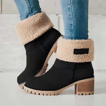 Women's green suede shearling block heel ankle boots worn on a foot, paired with jeans.