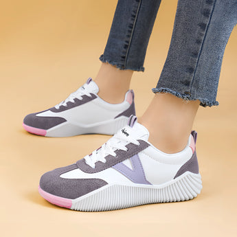 Women's grey casual sneakers with purple accents and a pink heel, displayed in a close-up shot highlighting the shoe's design and color details.