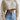 
A stylish women's grey cropped cable knit wool sweater designed for winter fashion, featuring intricate knit patterns and paired with jeans, highlighting a cozy and trendy outfit.