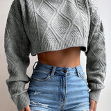 Women's grey cropped cable knit wool sweater with a stylish winter fashion design, featuring long sleeves and a textured cable knit pattern. The sweater has a round neck and a tailored fit around the waist, ideal for pairing with jeans for a chic winter look.