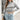 Women's grey cropped turtleneck sweater with an Aztec pattern, featuring long sleeves and a modern knit design.