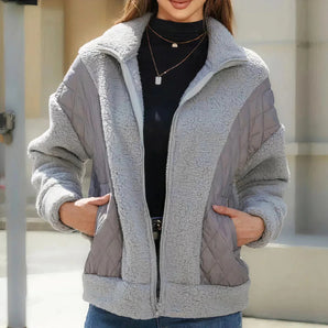 Women's grey fleece-lined hooded jacket with quilted sleeves, featuring a soft textile material, wrap design, and waist-length fit suitable for size 2XL.