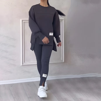Women's dark gray loungewear set in 3XL, featuring a stylish and comfortable sweatshirt with long sleeves and a round neck, paired with matching pants. The fabric appears soft and suitable for casual wear, embodying a modern fashion design in a versatile grey tone.