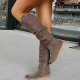 Women's grey suede over-the-knee boots featuring a stylish buckle detail, shown on a model wearing the boots with high heels, highlighting the knee and thigh area.
