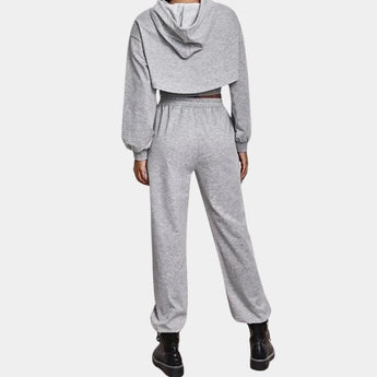 Women's grey tracksuit set featuring a cropped hoodie and joggers, showcasing an urban athleisure style with long sleeves and a comfortable waist fit.