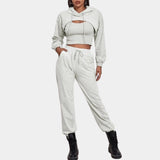 Women's grey tracksuit set featuring a cropped hoodie with long sleeves and a pair of joggers, designed for urban athleisure. The set is styled in a casual yet fashionable manner, suitable for everyday wear. The fabric appears soft and comfortable, with a focus on a sleek, modern look.