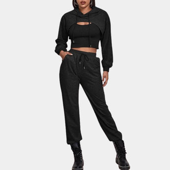 Women's grey tracksuit set featuring a cropped hoodie and joggers, displayed in a black, size XL variant. The set is designed for urban athleisure wear, highlighting the casual and stylish fit, with attention to detailing around the neck, sleeves, and waist.