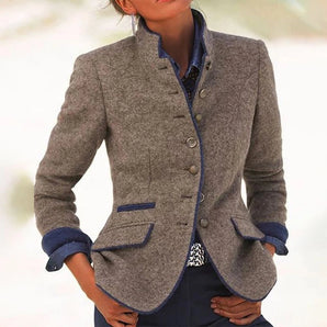 Women's grey wool blazer with blue trim, featuring a chic designer style, a collar, and long sleeves.