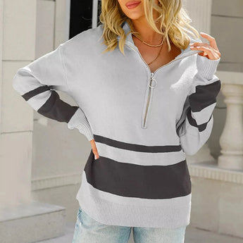 A woman wearing a gray-black color block sweater with a half-zip collar, long sleeves, and a casual fit, suitable for fall fashion.
