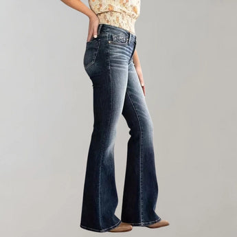 
A pair of women's high-waist dark wash flared stretch jeans being worn, highlighting the waist and leg fit with a flared design at the bottom.